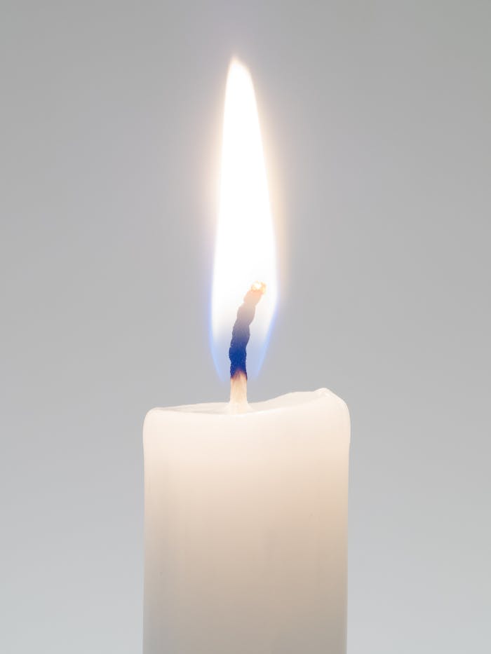 hero-img-01 A detailed view of a candle with a bright flame, perfect for themes of warmth, light, and serenity.