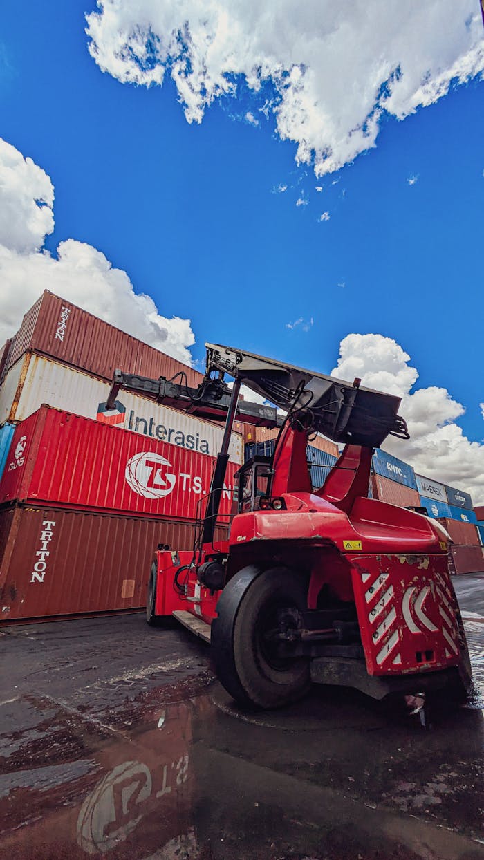 Crafting Captivating Headlines: Your awesome post title goes here Dynamic view of a red forklift amidst stacked shipping containers under a vibrant blue sky.